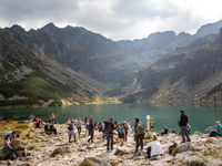 Tourists walk a mountain trail in the area of Black Lake and Granat summits in Tatra mountains, Poland as warm weekend attracted crowds on t...