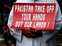 An Afghan national holds a placard during a protest against Pakistan's alleged support to the Taliban, in New Delhi, India on September 16,...