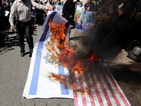 A Palestinian protester burns American and Israeli flags during a rally next the Red Cross building in Gaza City, on September 19, 2021. whe...