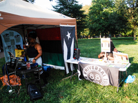 A DJ plays music in Tubman Park while a community elder puts together protest placards, during a rally in the Germantown section of Philadel...