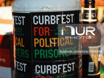 A donation bucket rests on the table of a DJ advertising for CurbFest, during a rally in the Germantown section of Philadelphia, PA, on Sept...
