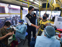Bangkok governor Asawin Kwanmuang visits the elderly people while receiving a dose of AstraZeneca COVID-19 vaccine in a vehicle of the BKK M...