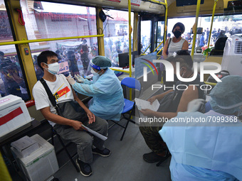 People receive a dose of AstraZeneca COVID-19 vaccine in a vehicle of the BKK Mobile Vaccination Unit on September 20, 2021 in Bangkok, Thai...