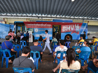 People are seen sit in front of the mobile vaccination unit while waiting to get a dose of AstraZeneca COVID-19 vaccine on September 20, 202...