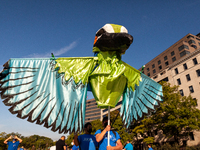 Protsters carry a huge motmot puppet during a march for permanent residency for immigrants with temporary protected status in the US.  Prote...