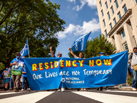 Protesters carry the lead banner during a march for permanent residency for immigrants with temporary protected status in the US.  Protester...