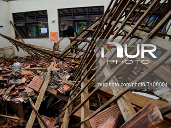 A man looks at the condition of the roof building on a class room that collapsed due to the weathered condition of the wood at primary schoo...