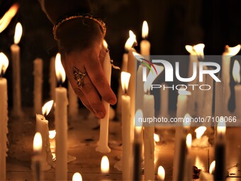 Women light a candle during a celebration of Madhu Purnima or Honey full moon at an international Buddhist monastery in Dhaka, Bangladesh on...