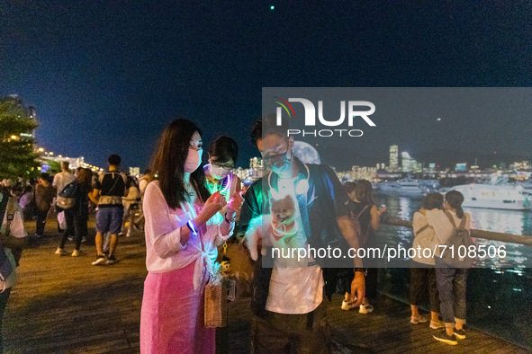 Hong Kong, China, 21 Sep 2021,  A couple brought their little dog with illuminations to take selfies in front of the giant inflatable moon i...