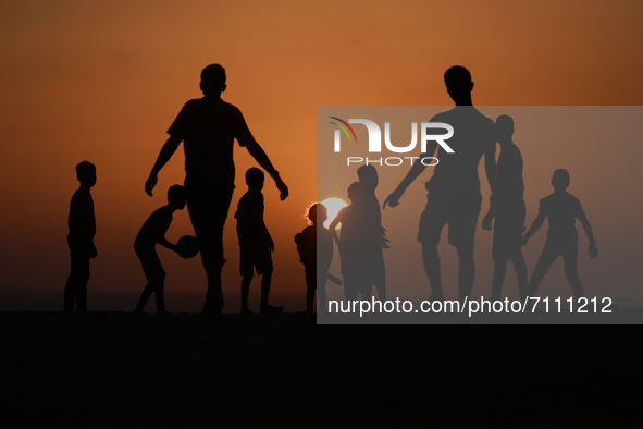 Palestinian boys play football during sunset in northern Gaza Strip, on September 21, 2021.
 