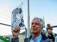 A man is holding a placard that say in Dutch 'this factory stinks, makes our neighborhood very sick', during a demonstration against the APN...