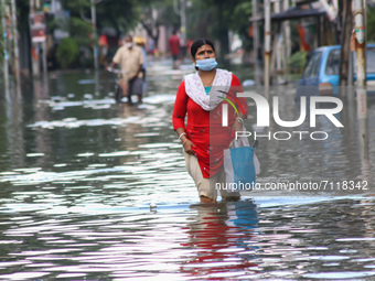 Commuters wade through a water logged street because of heavy rain and Coronavirus pandemic situation in Kolkata, India on September 23, 202...