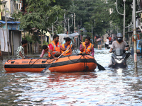 Disaster management team in a boat through the waterlogged area during a rescue operation after heavy rain on September 23, 2021 in Kolkata,...