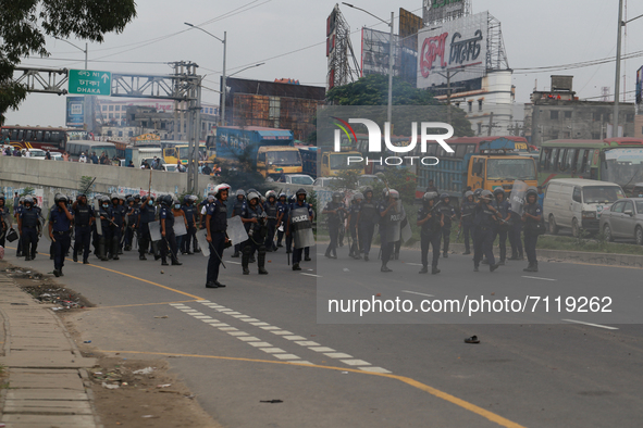 Law enforcers move towards garment worker protestors to displace them from Dhaka-Chattogram highway during a protest at Kanchpur in Narayang...