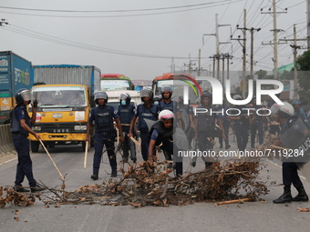 Law enforcers displace trees from Dhaka-Chattogram highway during a protest at Kanchpur in Narayangang, Bangladesh on September 23, 2021. (