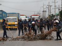 Law enforcers displace trees from Dhaka-Chattogram highway during a protest at Kanchpur in Narayangang, Bangladesh on September 23, 2021. (