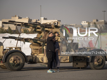 An Iranian couple take a selfie with an anti-aircraft gun while visiting a war exhibition which is held and organized by the Islamic Revolut...