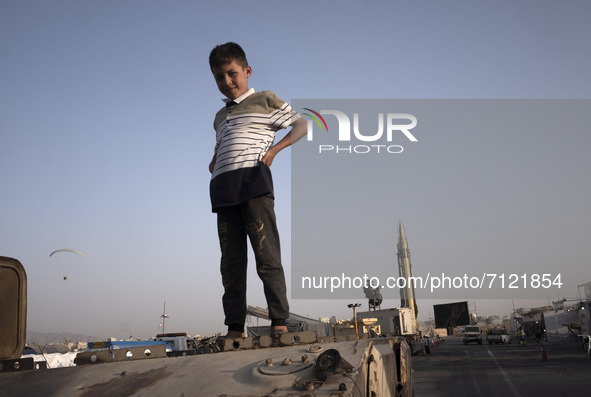 A young boy looks on as he stands on a military personnel carrier in a war exhibition which is held and organized by the Islamic Revolutiona...