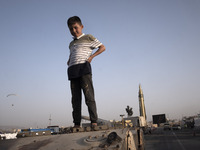 A young boy looks on as he stands on a military personnel carrier in a war exhibition which is held and organized by the Islamic Revolutiona...
