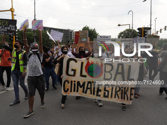 Protesters hold banners and placards as they participate in a march during a global climate strike as part of the 'Fridays for Future' movem...