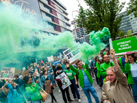 A woman is holding a green smoke bomb, during the Global Climate Strike organized in Utrecht, on September 24th, 2021. (