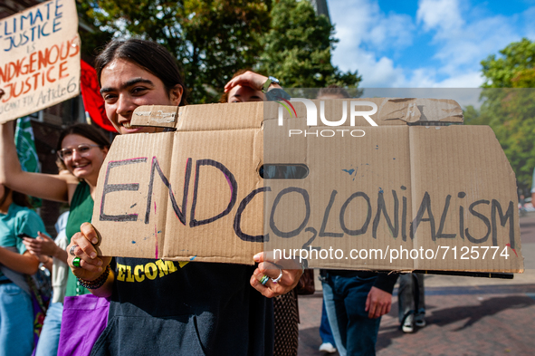 A woman is holding a placard against colonialism, during the Global Climate Strike organized in Utrecht, on September 24th, 2021. 