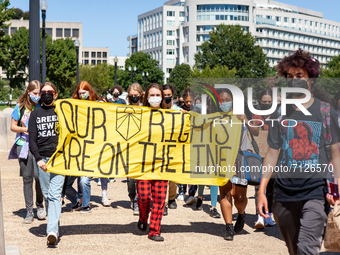 Teens with Sunrise Movement DC march to the reflecting pool on US Capitol grounds to join in the global climate strike by Fridays for Future...