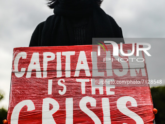 A woman holds a banner 'Capitalism Is the Crisis' during Climate Strike protest organized by Fridays for Future movement also known as Youth...