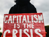 A woman holds a banner 'Capitalism Is the Crisis' during Climate Strike protest organized by Fridays for Future movement also known as Youth...