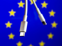 USB-C and Lightning cables are seen with European Union flag displayed in the background in this illustration photo taken in Krakow, Poland...