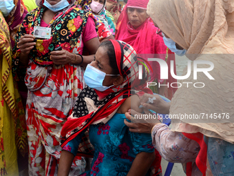 Slum people receive a dose of Sinopharm COVID-19 vaccine at a makeshift vaccination center at Korail Slum in Dhaka, Bangladesh, on September...