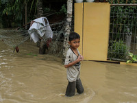 A child is seen walking through a flood caused by a river overflowing after heavy rains in North Aceh, on October 1, 2021, Aceh Province, In...