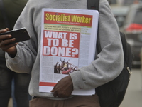 A protester holding a socialist newspaper with the headline ‘’WHAT IS TO BE DONE’’ during demanding the resignation of the President, Muhamm...