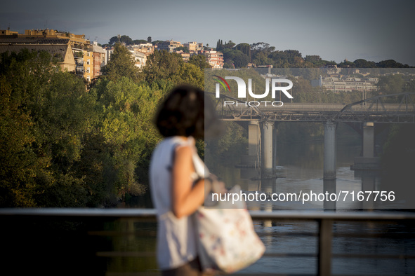 Italy, Rome: A woman looks  towards Ponte dell' Industria , also know as 'Ponte di Ferro' (iron bridge) which burned down for reasons yet to...