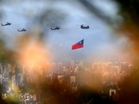 A military helicopter carrying a tremendous Taiwan flag flies over near  Taipei 101, as part of the rehearsal ahead of the Double-tenth nati...