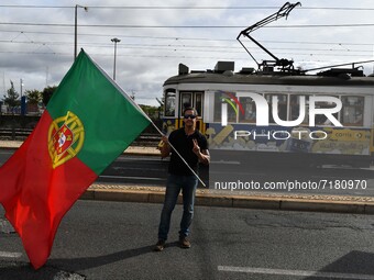 A teachers' union activist unfurls a Portuguese flag during a march in Lisbon. 05 October 2021. The Portuguese National Teachers' Federation...