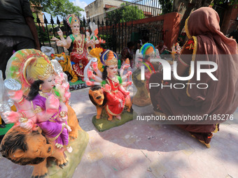 A woman artist gives final touches to an idol of Goddess Durga ahead of 'Durga Puja' festival, at a roadside workshop in Jaipur, Rajasthan,...