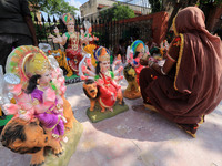 A woman artist gives final touches to an idol of Goddess Durga ahead of 'Durga Puja' festival, at a roadside workshop in Jaipur, Rajasthan,...