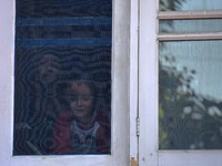 SRINAGAR, KASHMIR, INDIA-OCTOBER 07: Kids look on from the window of the house of school principal Satinder Kaur who was shot dead by gunmen...