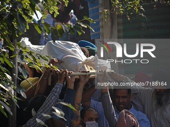 SRINAGAR, KASHMIR, INDIA-OCTOBER 07: People carry the body of school principal Satinder Kaur in the premises of her residence in Allocha Bag...