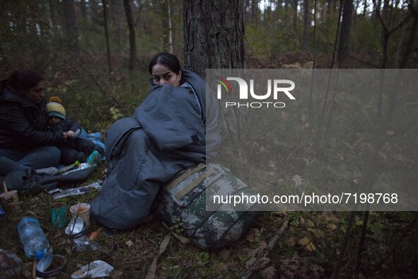Illegal immigrant sits in sleeping bag after crossing polish belarusian border near Michalowo on October 6, 2021. 