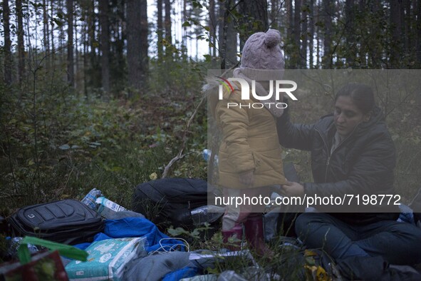 Mother dresses up her child after crossing polish belarusian border near Michalowo on October 6, 2021. 