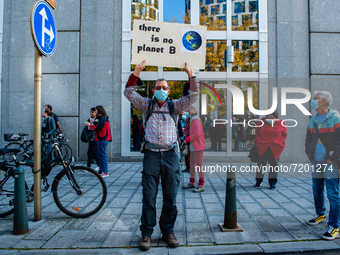 A man is holding a climate placard in the middle on the street before the demonstration Back to Climate started in Brussels, on October 10th...