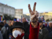 A woman protests showing V-sign gesture during 'We're staying in EU' demonstration at the Main Square in Krakow, Poland on October 10, 2021....