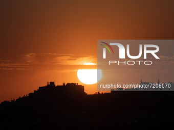 The sun at sunset seen from the Monte viewpoint, Lisbon. October 12, 2021. Tourists and locals gather at the different viewpoints of the Por...