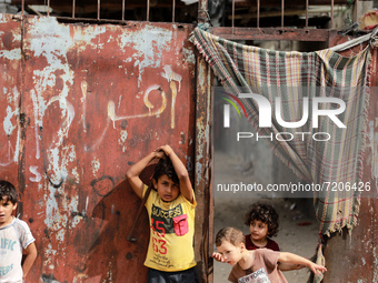 Palestinian children play next to their home in the Gaza Strip's al-Shati refugee camp in Gaza City on October 12, 2021. (