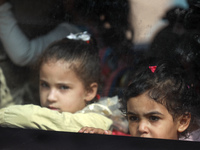 Palestinian children look out of a bus window at al-Shati refugee camp in Gaza City on October 12, 2021. (