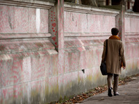 A woman walks beside the National Covid Memorial Wall on the south bank footpath of the River Thames opposite the Houses of Parliament in Lo...