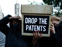 Members of activist group Global Justice Now campaigning for pharmaceutical companies to suspend patents on covid-19 vaccines carry mock cof...