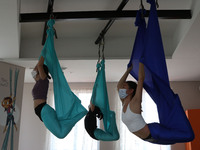 Women take an aerial yoga class at Aerial Jooga Studio using masks and health protocols in Serpong, South Tangerang, Indonesia on October 13...
